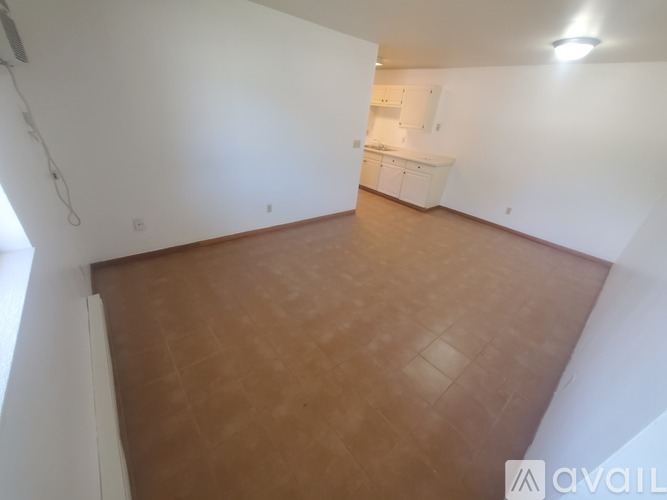 A room with wooden flooring and white walls.