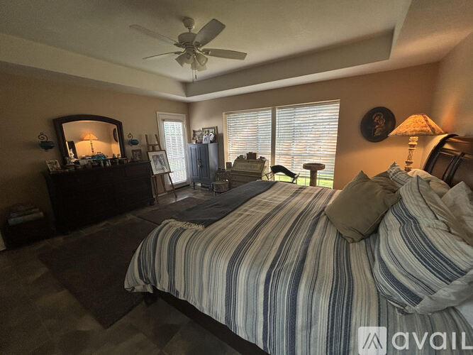A bedroom with a large bed and a ceiling fan.