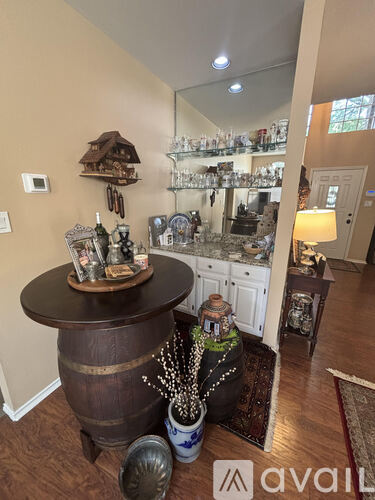 A kitchen with a wooden barrel table and a mirror above it.