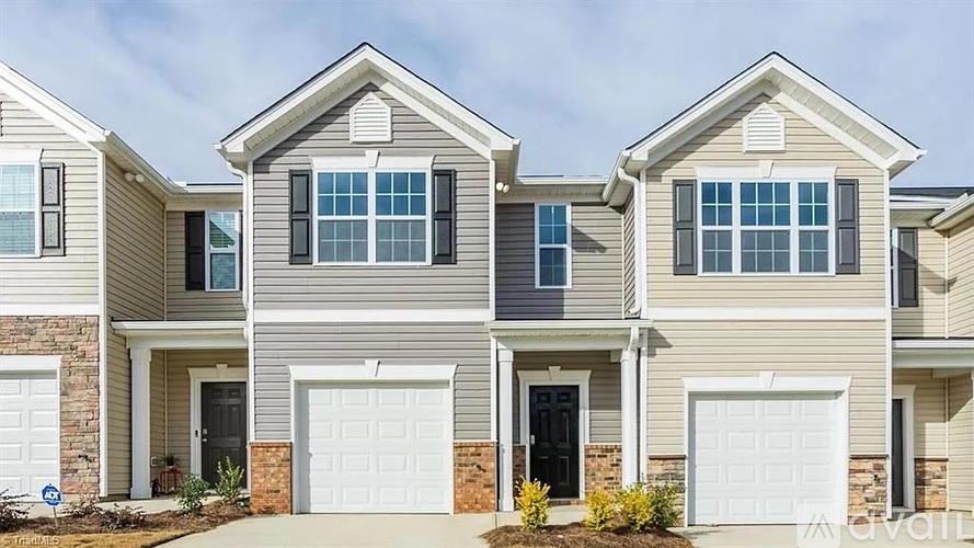 A row of houses with garages and driveways.