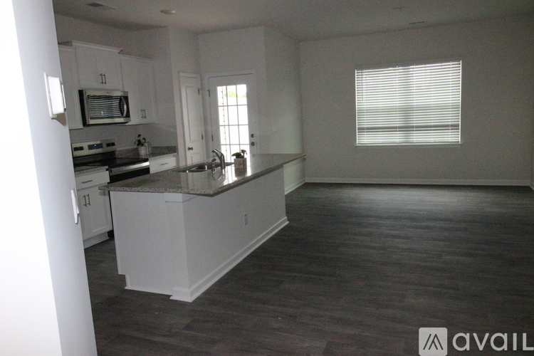 A kitchen with white cabinets and a granite countertop.
