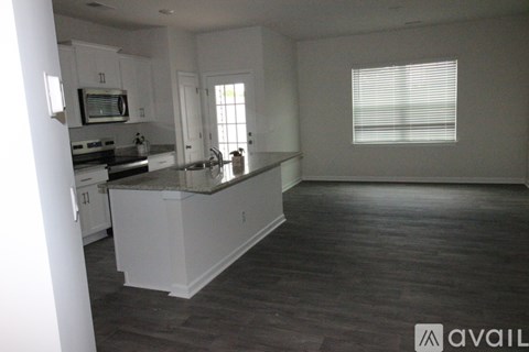 A kitchen with white cabinets and a granite countertop.