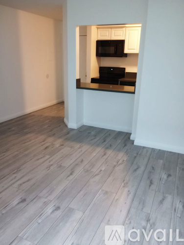 A kitchen with a wooden floor and white walls.