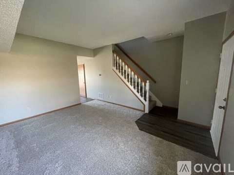 A spacious room with a staircase leading to the upper floor.