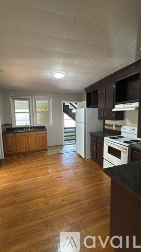 A kitchen with wooden floors and white appliances.
