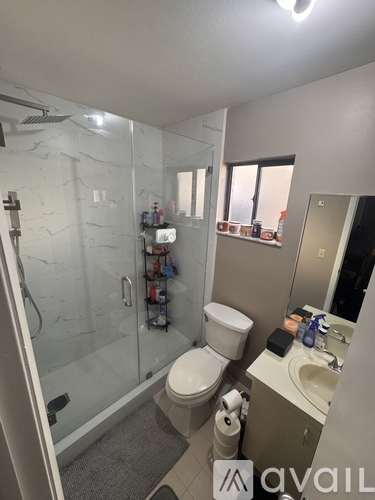 A bathroom with a toilet, sink, and shower.