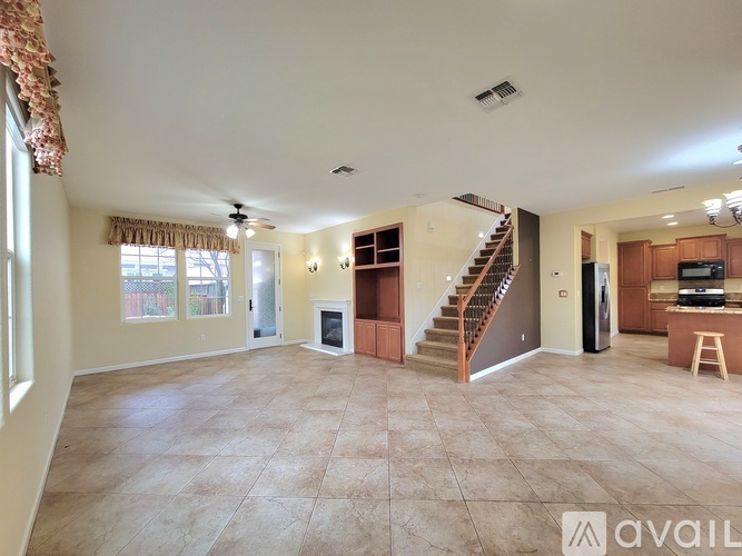 A spacious living room with a staircase leading to the upper floor.
