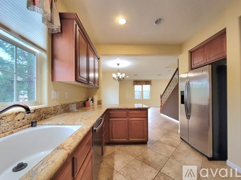 A kitchen with brown cabinets and a granite countertop.