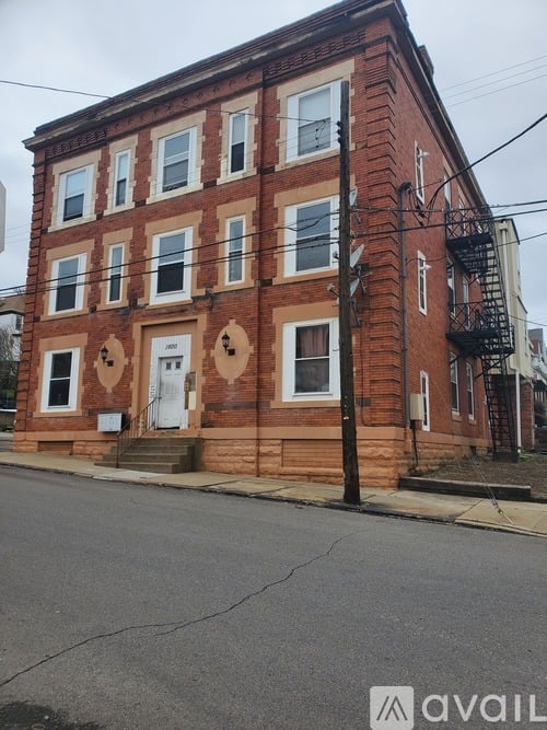 A red brick building with a white door and windows.