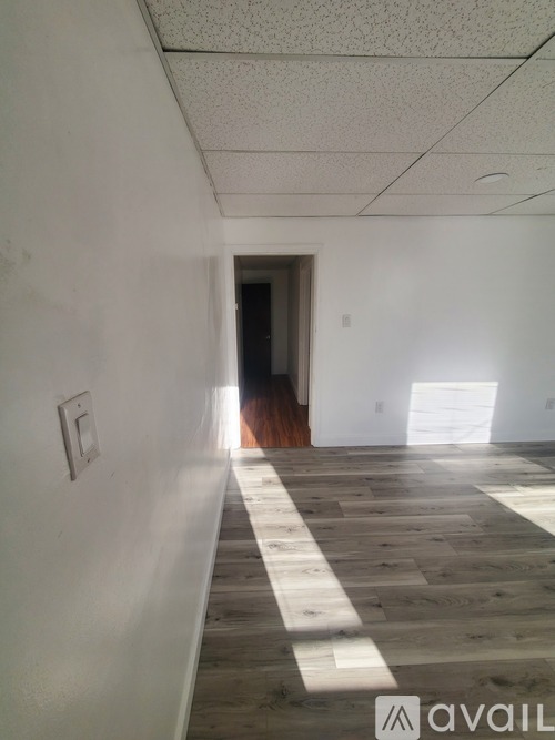 A room with a white wall and a wooden floor.