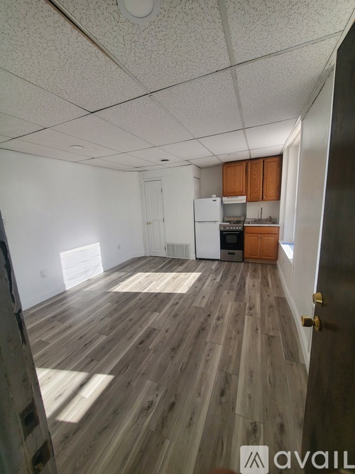A room with wooden floors and white walls is available for rent.