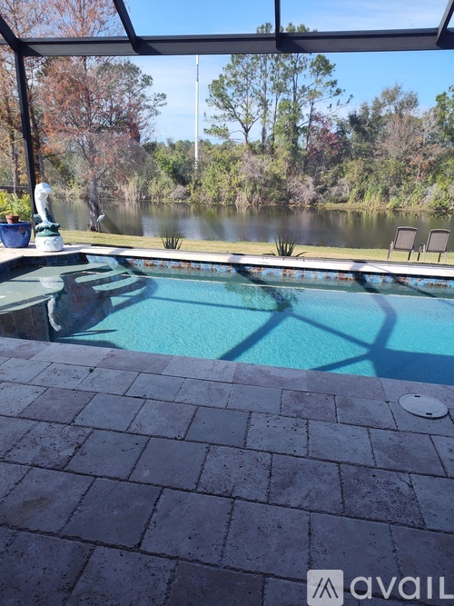 A pool with a view of a lake and trees.