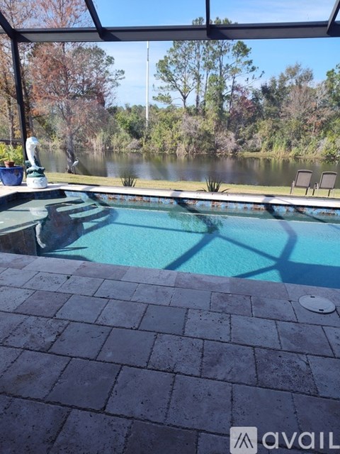 A pool with a view of a lake and trees.