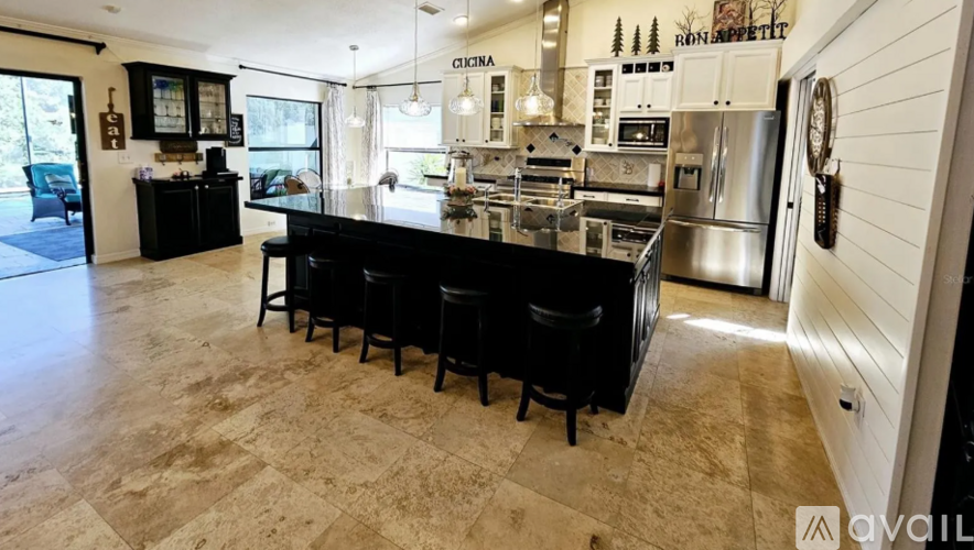 A kitchen with a black countertop and a refrigerator.
