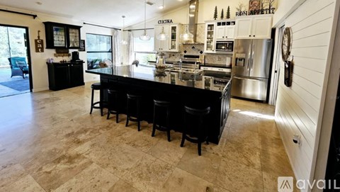 A kitchen with a black countertop and a refrigerator.