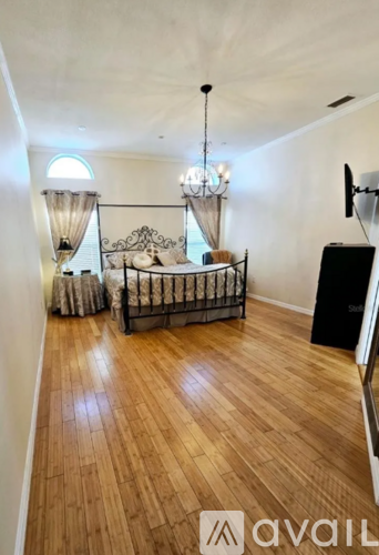 A bedroom with a canopy bed and wooden floors.