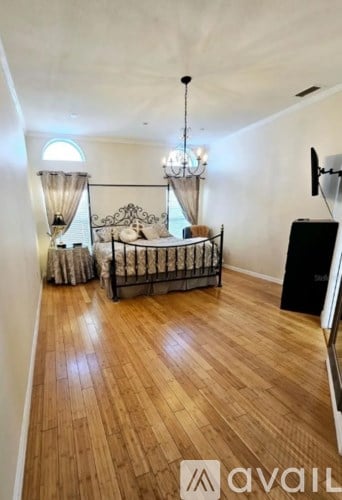 A bedroom with a canopy bed and wooden floors.