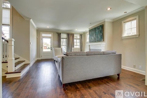 A living room with a grey couch and wooden floors.