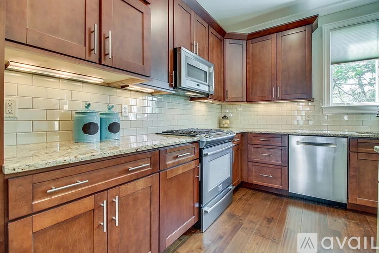 A kitchen with wooden cabinets and a stainless steel dishwasher.