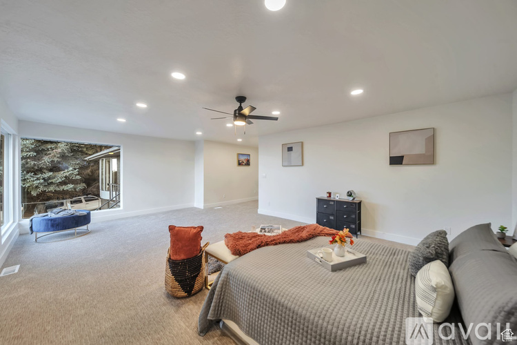 A bedroom with a large bed and a ceiling fan.
