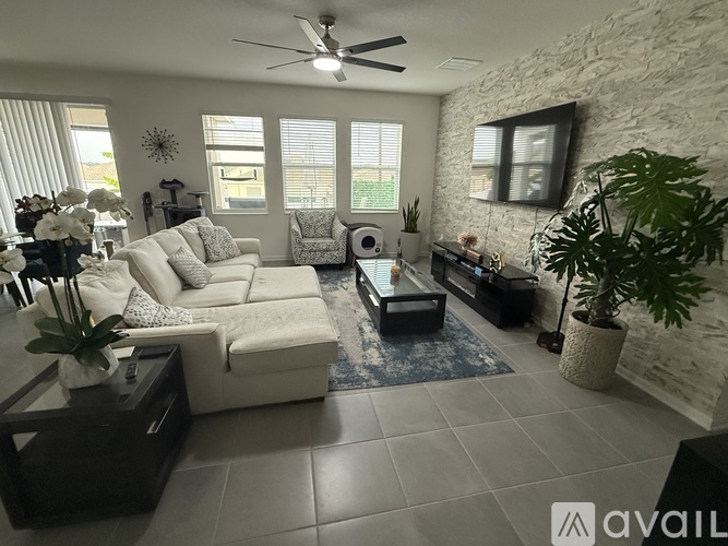A living room with a white couch, a coffee table, and a ceiling fan.