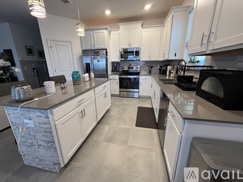 A kitchen with white cabinets and a black stove top oven.