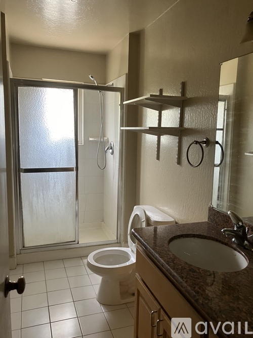 A bathroom with a toilet, sink, and shower.