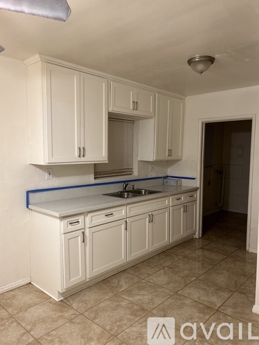 A kitchen with white cabinets and a countertop.
