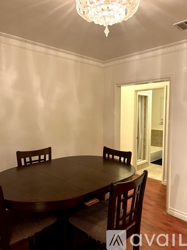 A dining room with a round table and chairs.