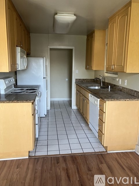 A kitchen with wooden cabinets and a white fridge.