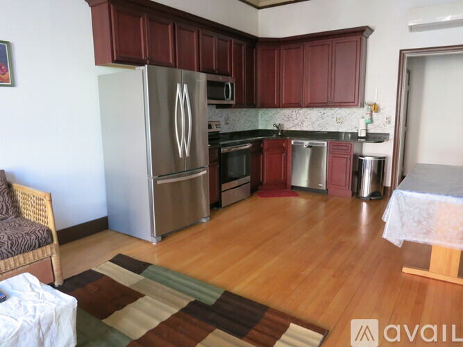 A kitchen with wooden floors and a refrigerator.