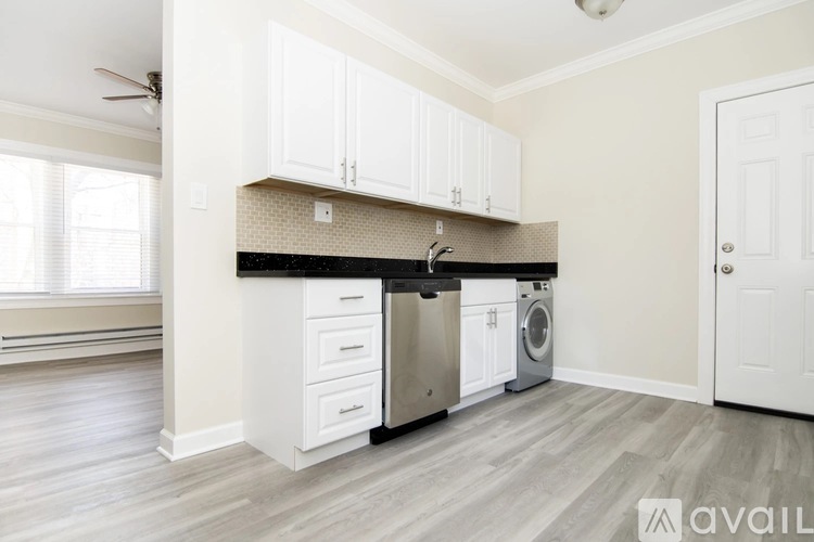 A kitchen with white cabinets and a black countertop.