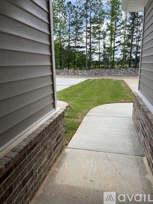 A view from a house looking out to a green lawn and trees.