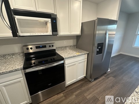 A kitchen with a stove, microwave, and refrigerator.