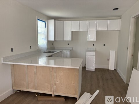 A kitchen under construction with wooden cabinets and a countertop.