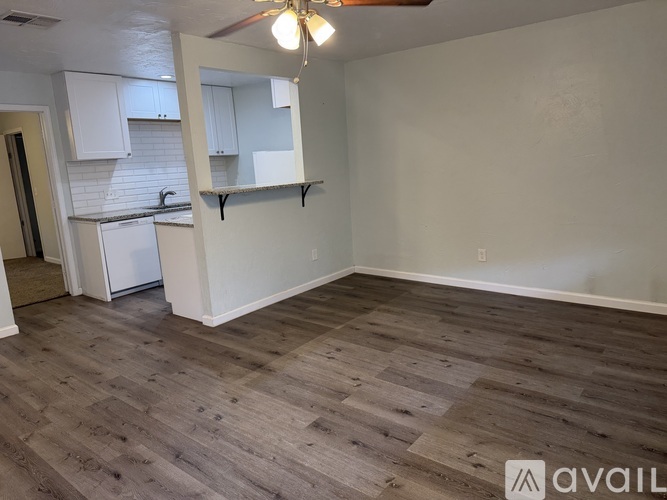 A room with wooden flooring and a wall-mounted shelf.