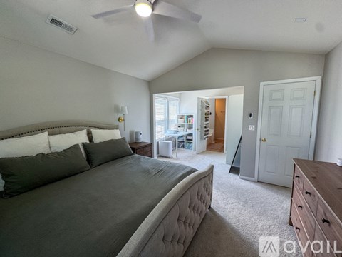 A bedroom with a large bed and a ceiling fan.