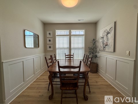 A dining room with a wooden table and chairs.