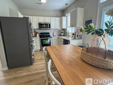 A kitchen with a wooden table and a black refrigerator.