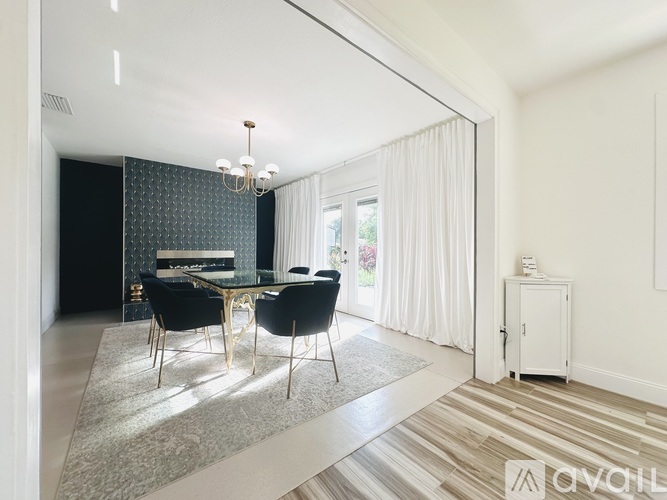 A modern dining room with a glass table and chairs.