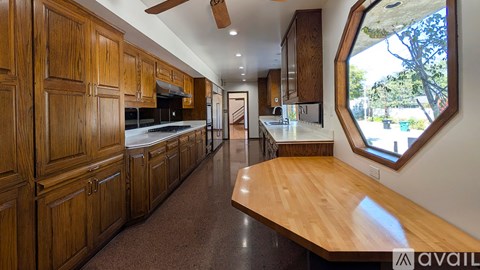 A kitchen with wooden cabinets and a long island.