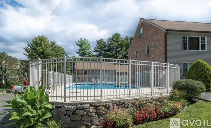 A house with a pool surrounded by a fence and some plants.