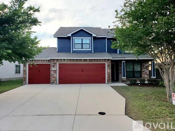 A house with a red garage door and a blue house with a grey roof.