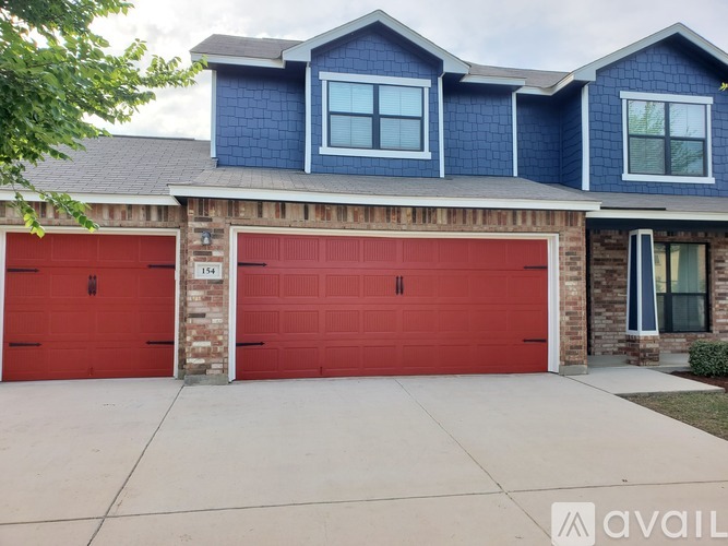A house with a blue exterior and two red garage doors.