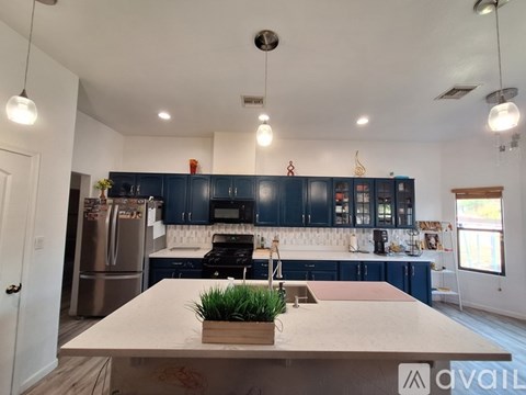 A kitchen with a refrigerator, oven, and sink.