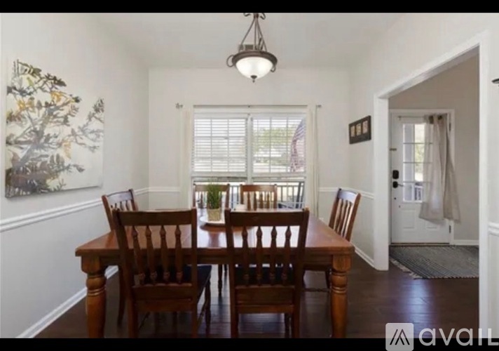 A dining room with a wooden table and chairs.