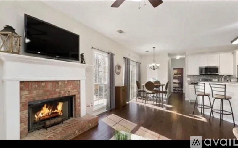 A living room with a fireplace and a television on the wall.