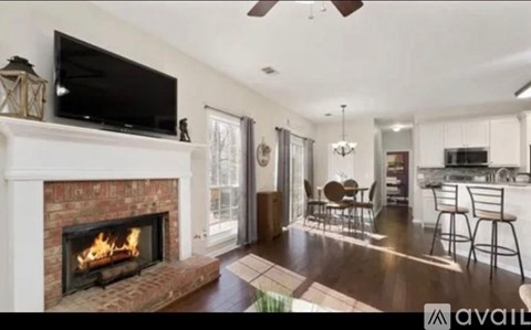 A living room with a fireplace and a television on the wall.