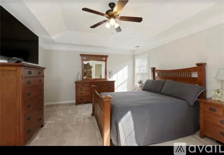 A bedroom with a bed, dresser, and mirror.