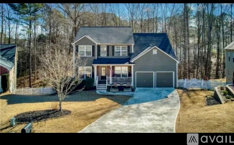 A house with a grey roof and a blue pool in the backyard.